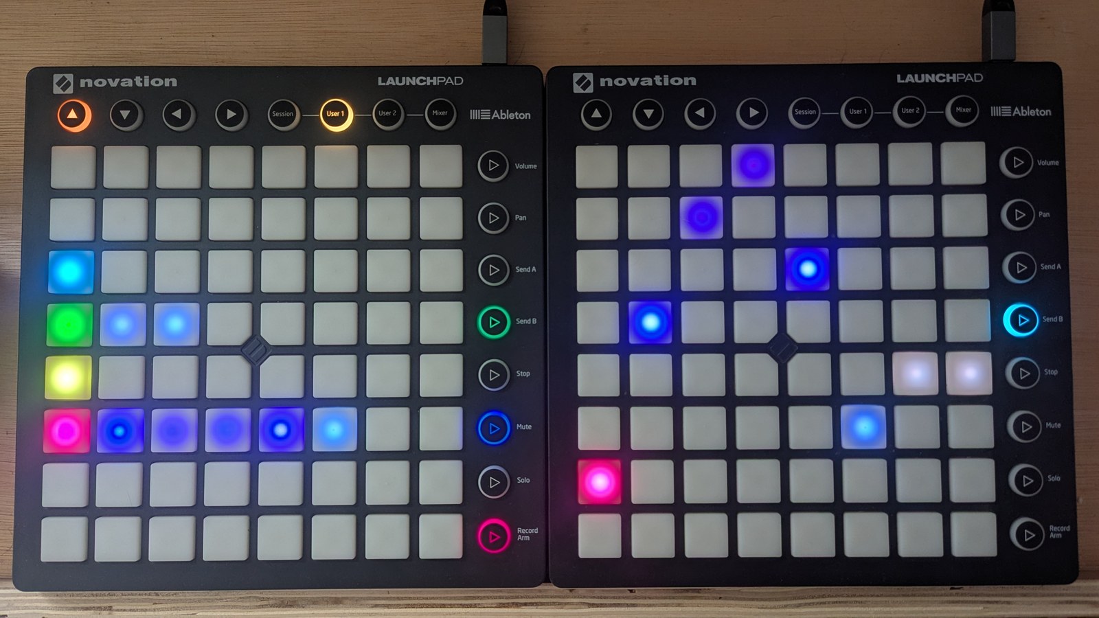 A CC-arp view: on the LP LHS a green row with three lit pads and a pink row with six, in the palette colour at the head of each run and blue value gradations behind; a sky-blue and a lime row carry a single blinking pad in column 1, and the remaining four rows are dark. On the LP RHS, single pads trace the pink row's six values rising to the top and falling again, followed by two slate pads, photographed on the hardware