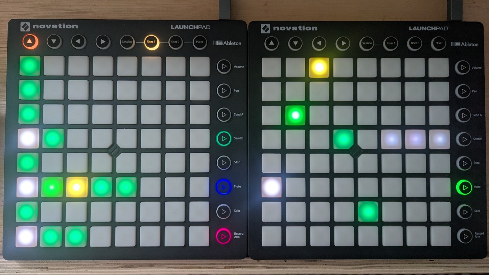 A duty-arp view: the LP LHS's first column is lit on every row, with runs of two, five and three lit pads on three of them in white and the green-to-yellow duty palette; the LP RHS shows one lit pad per step at varying heights, the first in white and the last three in slate, photographed on the hardware